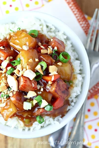 sweet and sour ham in a bowl with a bed of rice under it 