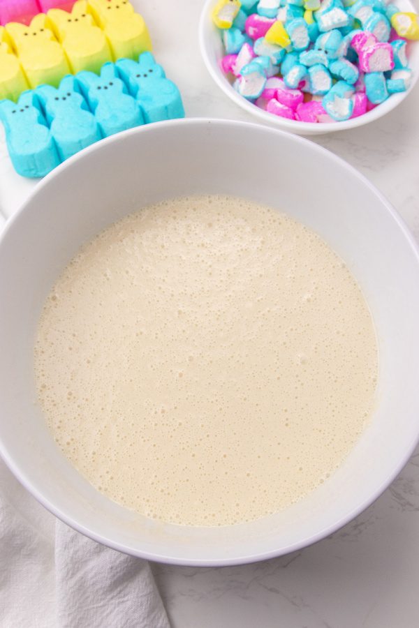 Easter peeps pancakes are a fluffy pancake filled with bits of peeps. This is a marshmallow pancake perfect for Easter morning breakfast. #passion4savings #easter #pancakes #peeps #tradition #spring #morning #eastermorning biscuick pancake batter in white bowl