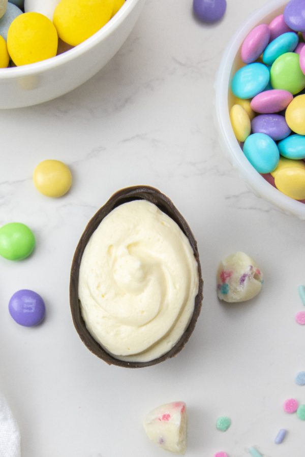 Loaded Cheesecake Easter Eggs are a chocolate candy egg filled with cheesecake and topped with Easter candy. An easy make ahead Easter treat. These fun Easter egg desserts will steal the show. #passion4savings #easter #eggs #dessert #nobake #cheesecake #howto #makeahead cheesecake dessert