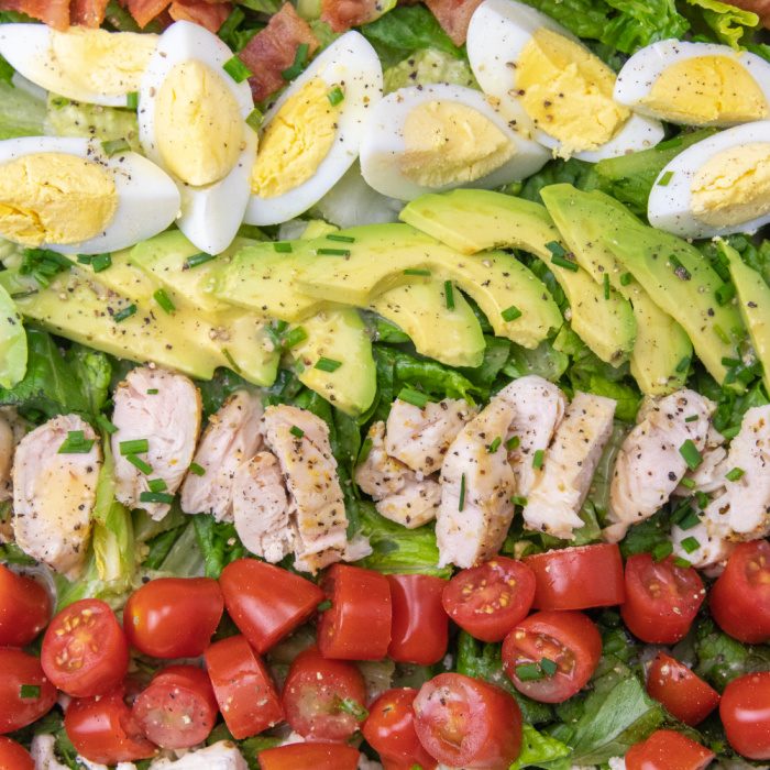 Sheet Pan Cobb Salad For A Crowd that is ready in no time. Tender chicken, loads of veggies, eggs, cheese and dressing. A must try. #passion4savings #cobb #salad #dinner #healthy #foracrowd #dinner #lunch #easy overhead shot of salad on sheet pan