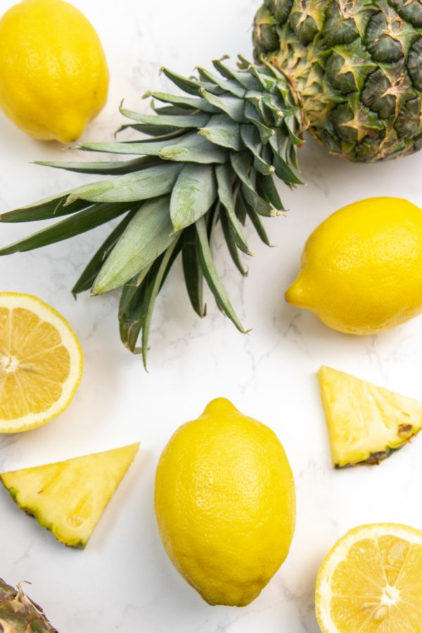 pineapple and lemons on marble counter 
