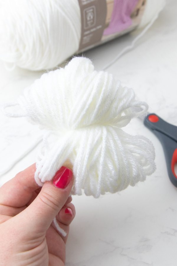 cutting yarn with scissors in hand