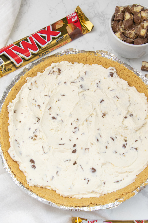 No bake Twix pie is an easy no bake pie. Cool Whip, Twix candy bars, chocolate, caramel and more. A simple and easy no bake pie recipe. #twix #pie #nobake #dessert #passion4savings #easy #best #summer #spring #potluck candy bar pie overhead shot