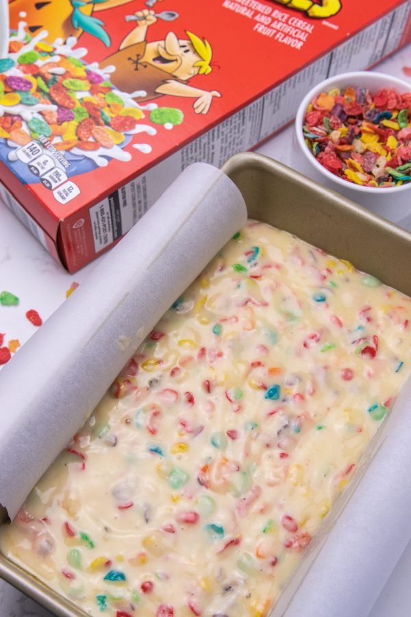 Whip up this Fruity Pebbles bread! A quick bread recipe that is studded with sweet Fruity Pebbles in each bite. A must try dessert bread. #dessert #fruitypebbles #cereal #bread #snack #howtomake #breadrecipe #quickbread #cerealdessert cereal bread dough in pan