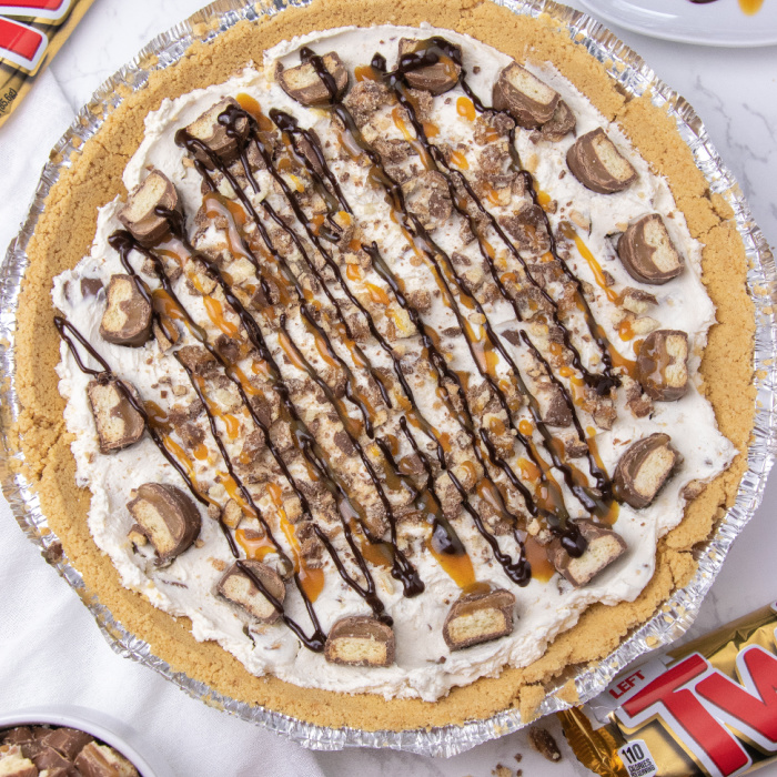 No bake Twix pie is an easy no bake pie. Cool Whip, Twix candy bars, chocolate, caramel and more. A simple and easy no bake pie recipe. #twix #pie #nobake #dessert #passion4savings #easy #best #summer #spring #potluck overhead shot of Twix pie