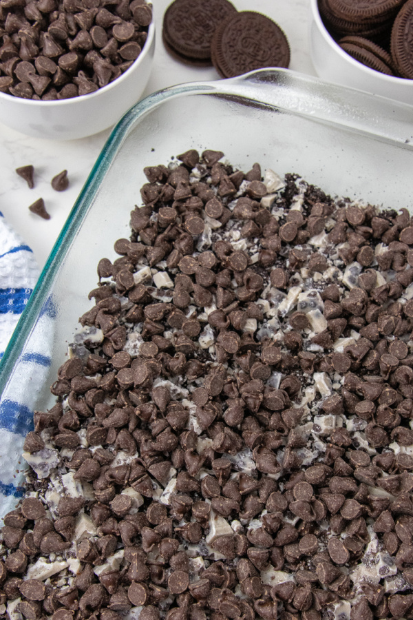 Oreo Magic Bars take minutes to make, and are delicious sweet magic bars. Loaded with cookies and cream bars, Oreos, chocolate chips and more. Give this easy Oreo cookie recipe a try today. #passion4savings #oreo #cookiesandcream #easy #quick #partyfood #dessert overhead view of magic bars in pan