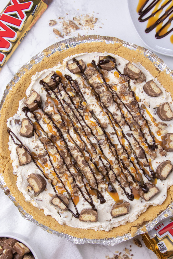 No bake Twix pie is an easy no bake pie. Cool Whip, Twix candy bars, chocolate, caramel and more. A simple and easy no bake pie recipe. #twix #pie #nobake #dessert #passion4savings #easy #best #summer #spring #potluck easy twix pie