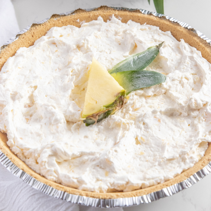 Dole whip pie is a creamy pineapple pie that is made with crushed pineapple and cream cheese. So easy and a tasty no bake pineapple recipe. #passion4savings #Pineapple #pie #dolewhip #easy #nobake #summer #spring #potluck #makeahead pineapple pie