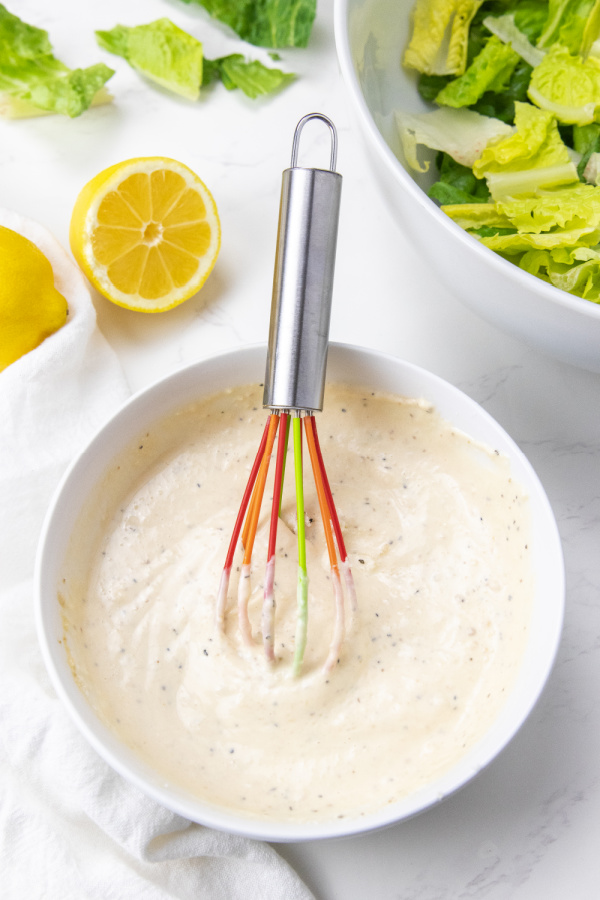 mixing up caesar dressing in bowl 
