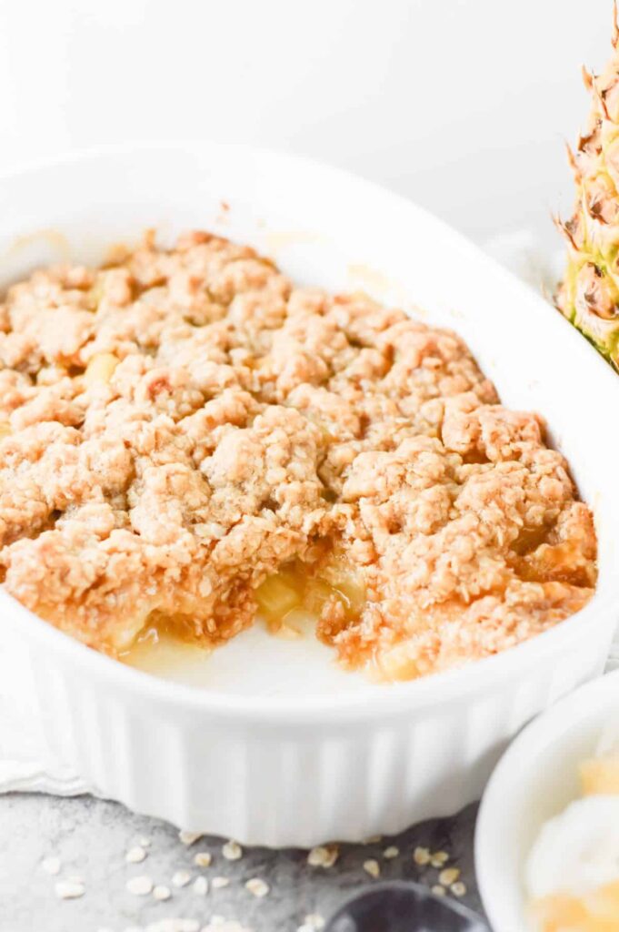 pineapple crisp in pan with scoop taken out 