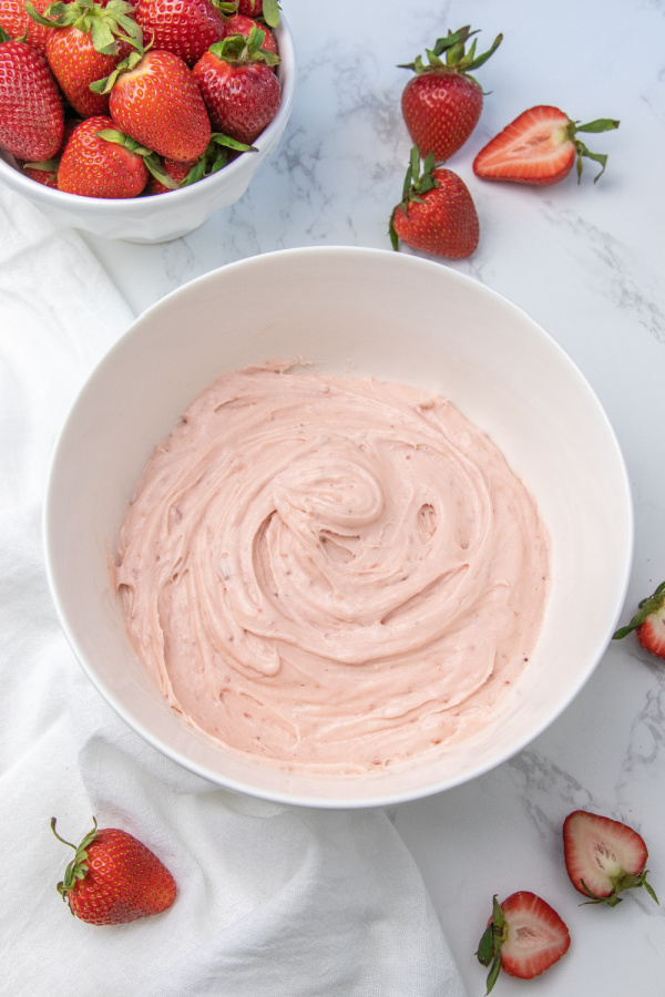 Here is our tried and true strawberry frosting recipe. 3 ingredients with big flavor. Use for cakes, cookies, cupcakes and more. #passion4savings #frosting #strawberries #dessert #strawberrypreserves #3ingredients #easy #best #triedandtrue strawberry frosting in bowl