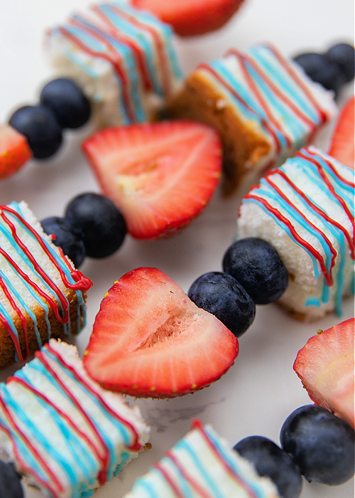 strawberries, blueberries, and shortcake on red white and blue skewers