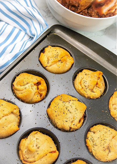 baked cheesy sloppy joe bombs sitting next to a blue-striped towel