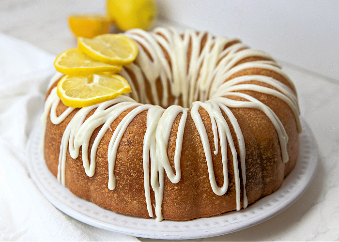 Lemon Pound Cake on a White Platter with Lemons 
