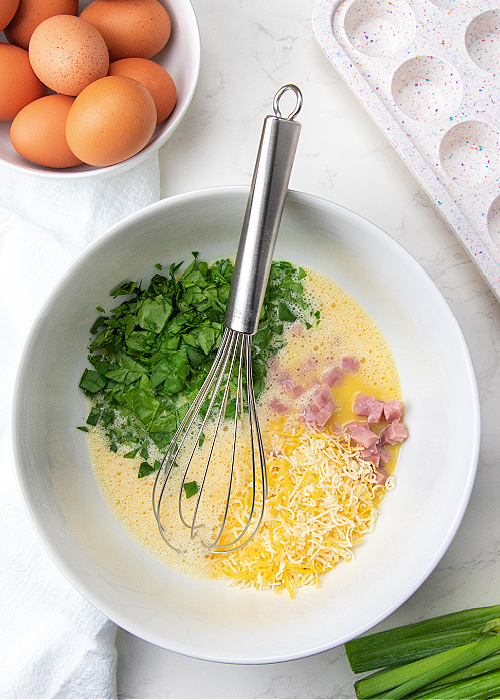 egg bites for kids ingredients in a mixing bowl
