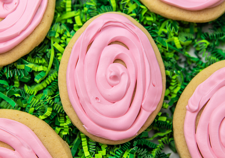 easter egg shaped crumbl copycat cookies placed on green easter grass