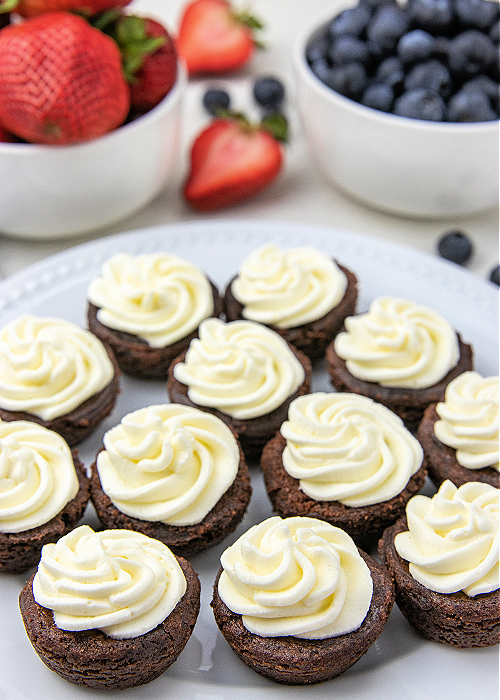 4th of July Brownie Bites are a colorful dessert for all your patriotic parties! Red, white, and blue with strawberries and blueberries! brownie bites with homemade whipped cream piped on top