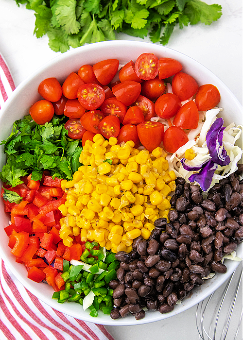 vegetables and beans combined in a mixing bowl for Mexican Coleslaw
