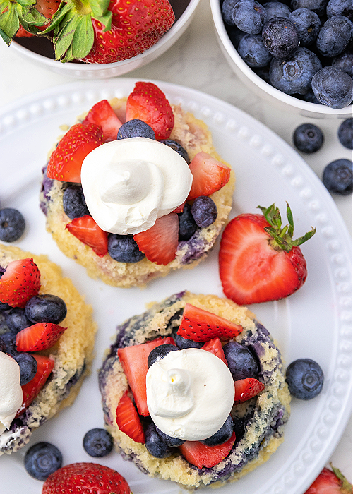 These Blueberry Strawberry Shortcakes are so flavorful, refreshing, light and perfect for all of your patriotic summer parties! three blueberry strawberry shortcakes on a white serving platter