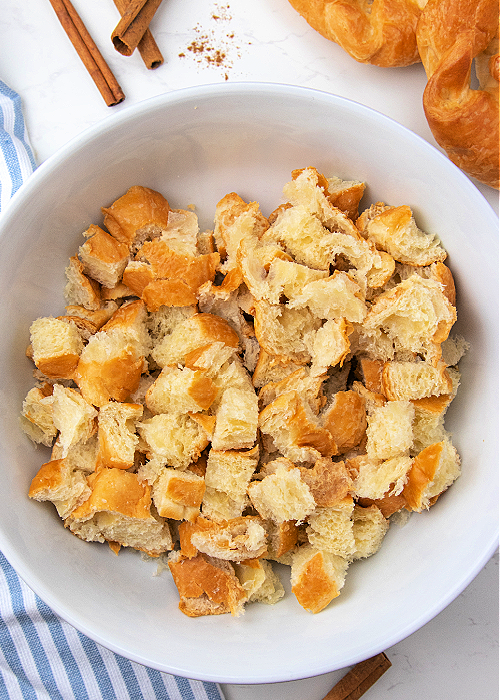 French Toast Muffins are delicious and easy to bake! Cinnamon and croissants combine for mega flavor in a convenient muffin-size serving! cubes of croissant in a bowl