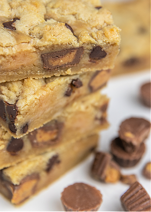 peanut butter cup gooey cookie bars sliced and stacked 