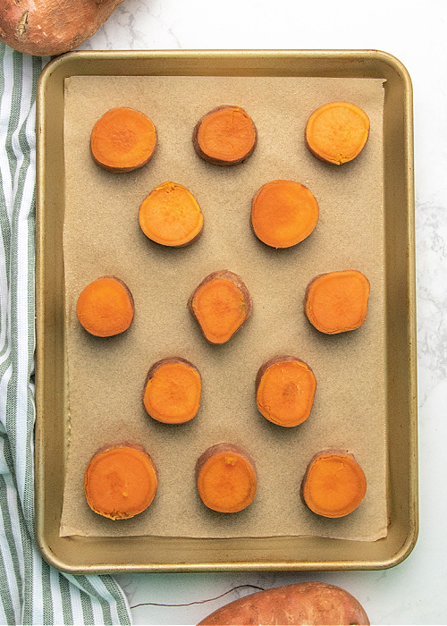 These Garlic Parmesan Smashed Sweet Potatoes are the perfect modern addition to your Thanksgiving meal or any dinner, for that matter! garlic parmesan smashed sweet potatoes on a cookie sheet