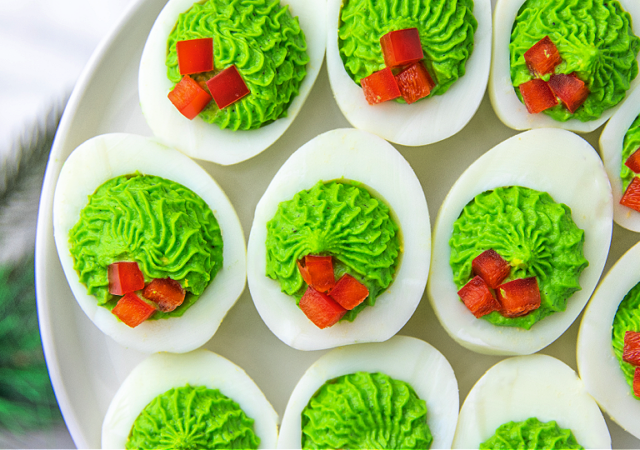 red and green christmas deviled eggs on a serving tray