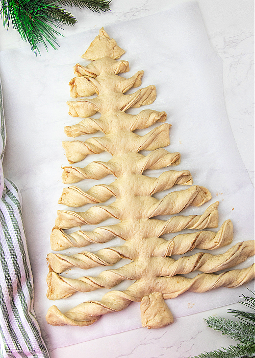 twisted pizza dough with cinnamon and sugar in the shape of a christmas tree