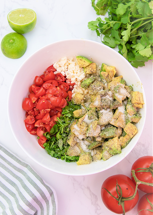 Avocado Crack Dip is SO fresh and flavorful and the perfect gameday dip recipe! Spices, cilantro, feta cheese and more combine for the perfect scoopable game day snack! ingredients for avocado crack dip in a mixing bowl