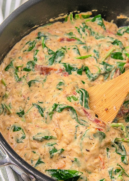 Creamy Garlic Butter Tuscan Shrimp Pasta is a delicious one-pan meal that is healthy, too! Sun-dried tomatoes, parmesan, garlic, and herbs combine for impeccable flavor! sauce for Creamy Garlic Tuscan Shrimp Pasta in a skillet
