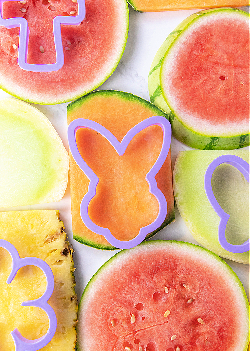 cookie cutters on fruit to be cut out for an easter fruit basket