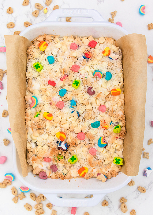 These Lucky Charms Magic Cookie Bars combine cereal with a classic! Perfect for St. Patrick's Day, this dessert is easy to make and looks festive, too! lucky charms magic cookie bars in a white baking dish
