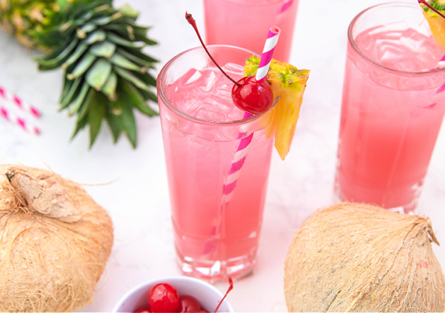 pink pina colada punch in a glass with a pink and striped white straw