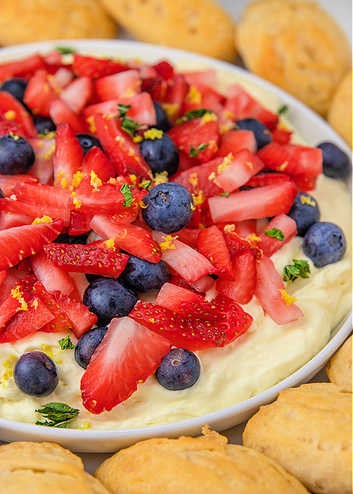 strawberry and blueberry patriotic shortcake dip with biscuit dippers surrounding the serving plate