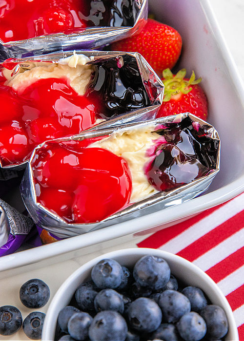 walking pretzel salad with cheesecake filling, cherry pie filling and blueberry pie filling