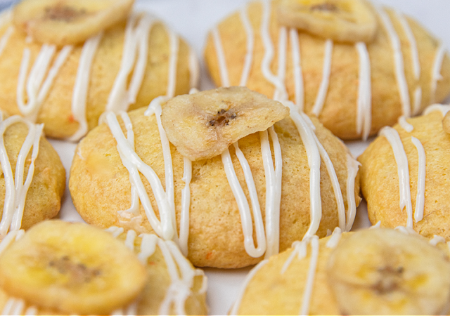 banana bread cookies drizzled in vanilla frosting and topped with a banana chip