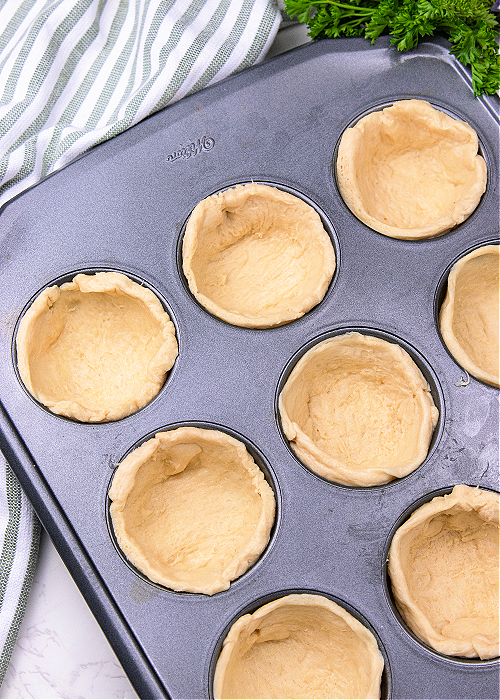 how to make pizza cupcakes step by step image with crescent roll dough in a muffin tin