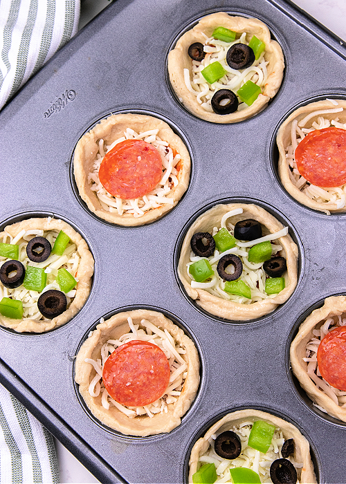 pizza cups in a muffin tin before baking