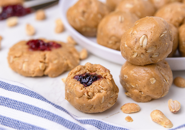 peanut butter and jelly protein bites on a serving platter with a striped napkin