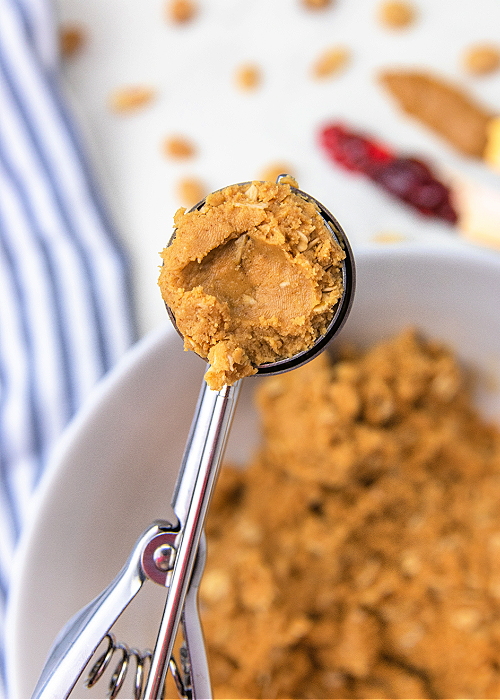 peanut butter and jelly protein bite dough in a cookie scoop before rolling into a ball