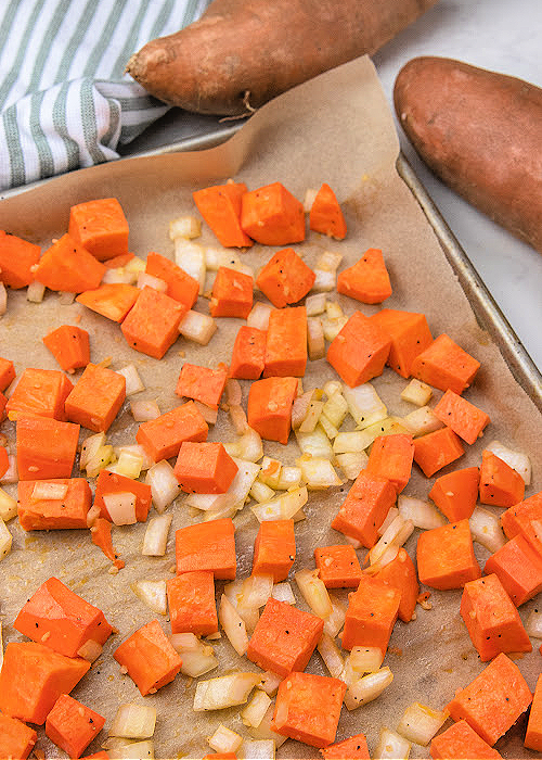 sweet potatoes roasted on a baking sheet covered in parchment paper