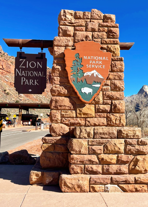 how to save money on national park trips zion national park sign
