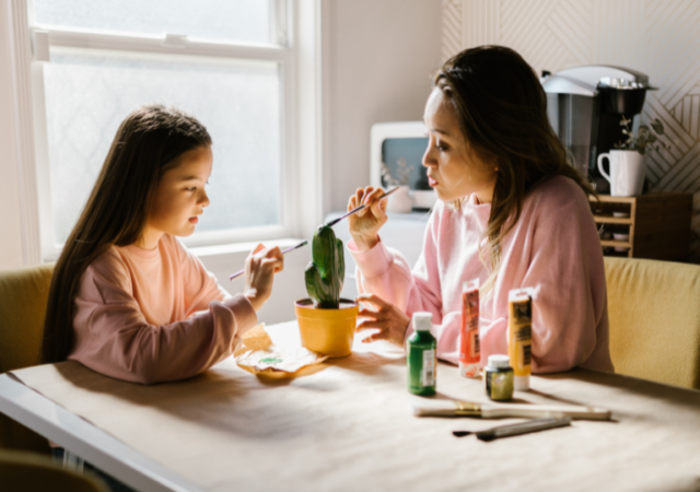 a mom and daughter staying home and doing a craft