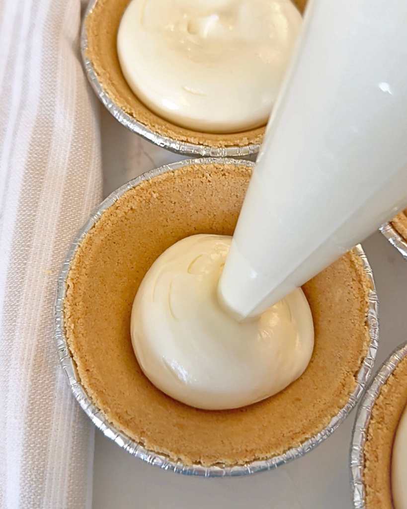 piping no bake cheesecake into pan